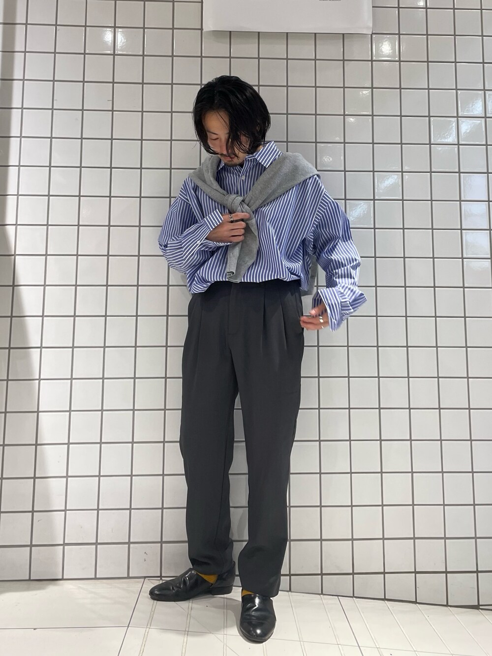 ブルー系のシャツ/ブラウス、グレー系のカーディガン/ボレロ、グレー系のスラックスを着用したメンズの春コーディネートの1枚目の写真