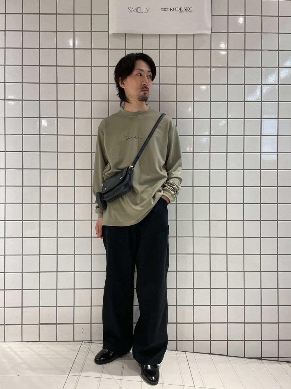 グリーン系のTシャツ/カットソー、ブラック系のショルダーバッグ、ブラック系のその他パンツを着用したメンズの春コーディネートの1枚目の写真