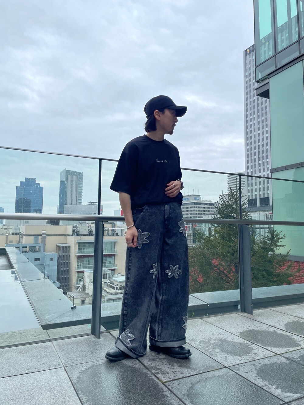 ブラック系のTシャツ/カットソー、ブラック系のデニムパンツを着用したメンズの春コーディネートの1枚目の写真