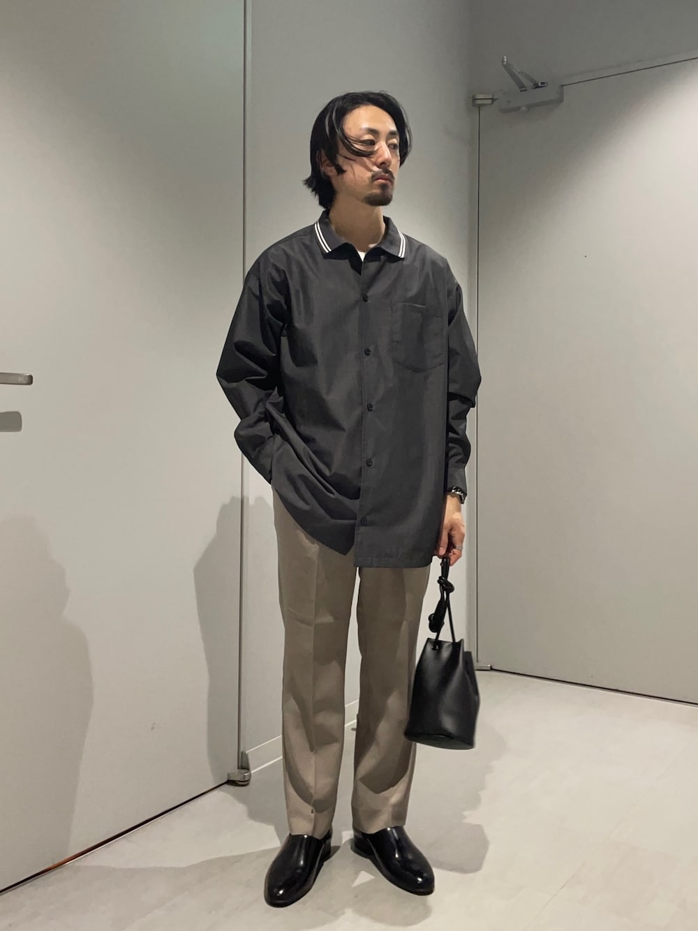 ブラック系のシャツ/ブラウス、ベージュ系のその他パンツ、ブラック系のショルダーバッグを着用したメンズの春コーディネートの1枚目の写真