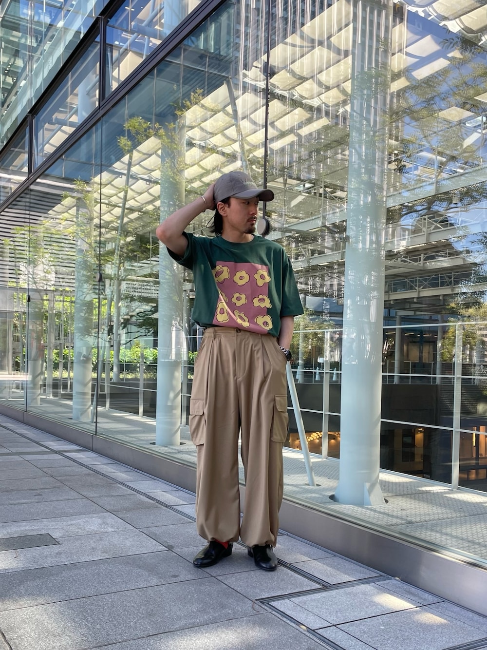 グリーン系のTシャツ/カットソー、ベージュ系のカーゴパンツ、ブラウン系のキャップを着用したメンズの夏コーディネートの1枚目の写真