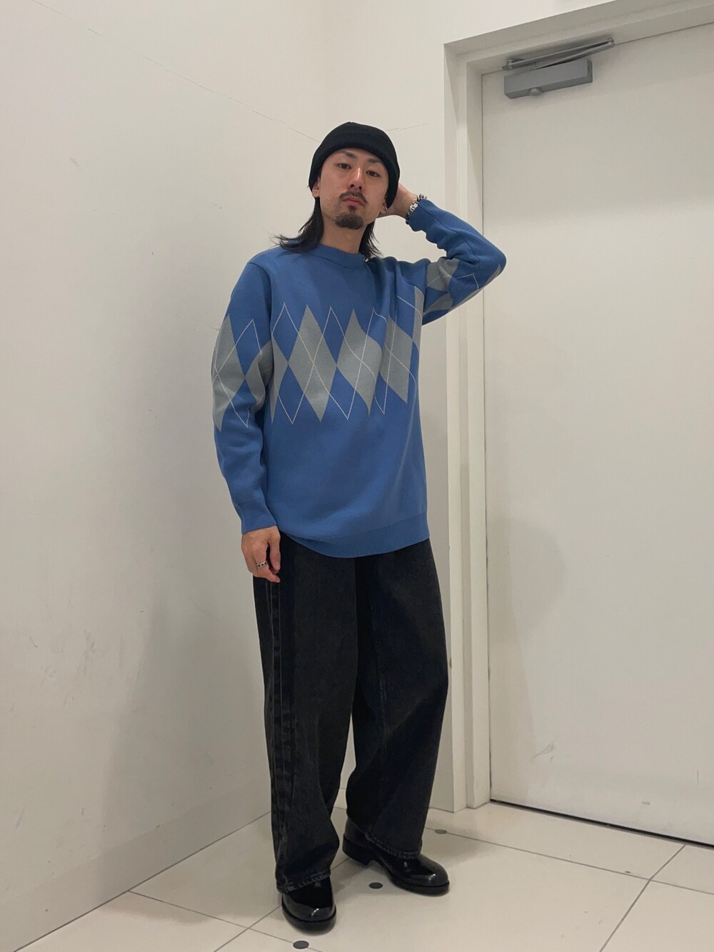 ブルー系のニット/セーター、ブラック系のデニムパンツを着用したメンズの冬コーディネートの1枚目の写真