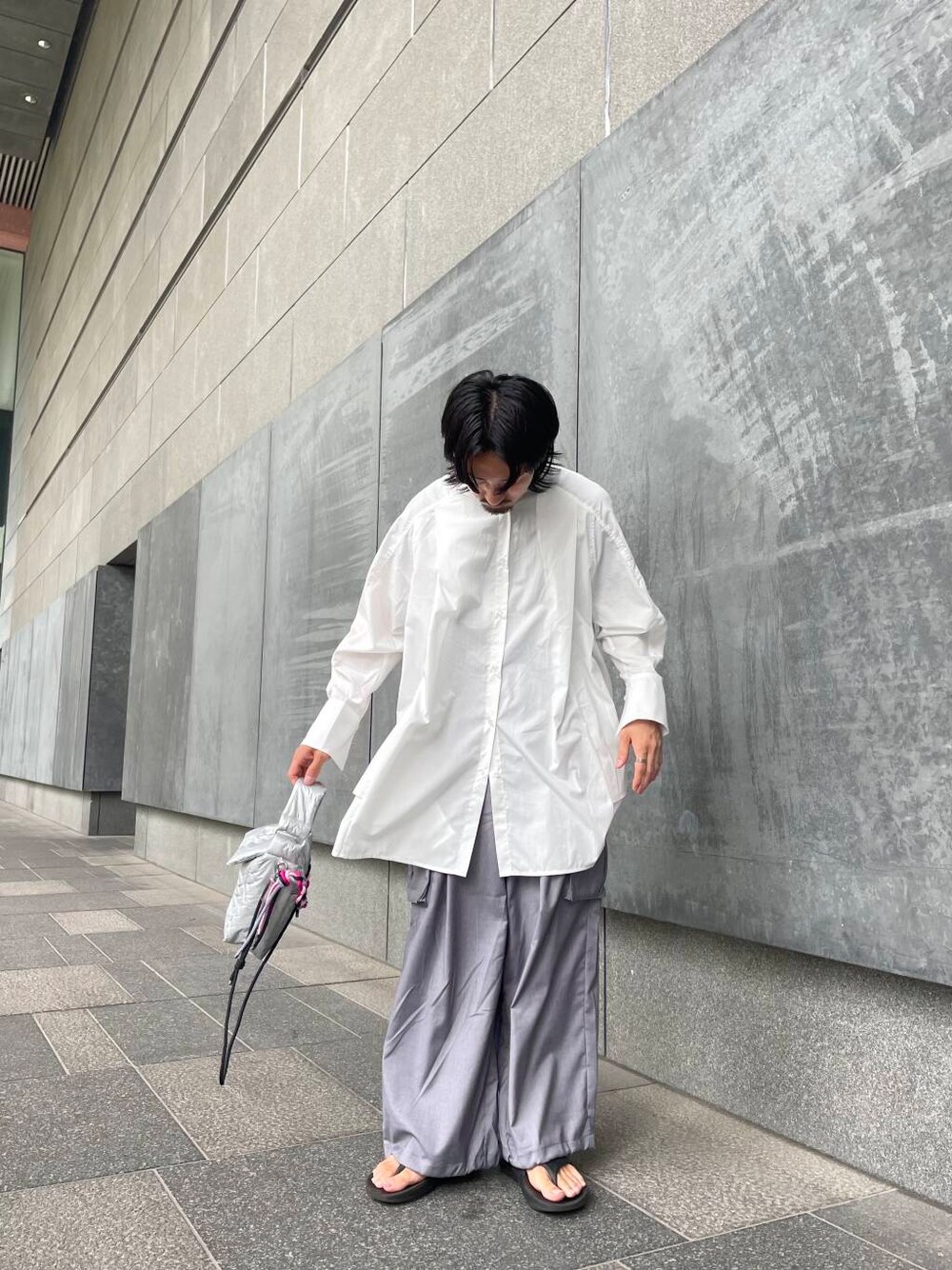 グレー系のカーゴパンツ、ホワイト系のワンピース、シルバー系のハンドバッグを着用したメンズの夏コーディネートの1枚目の写真