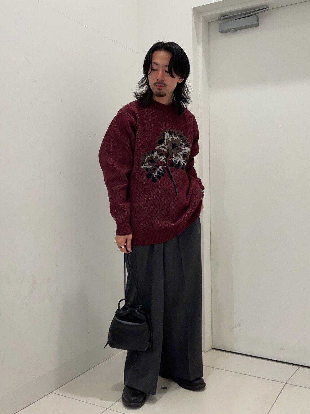 レッド系のニット/セーター、グレー系のその他パンツを着用したメンズの秋コーディネートの1枚目の写真