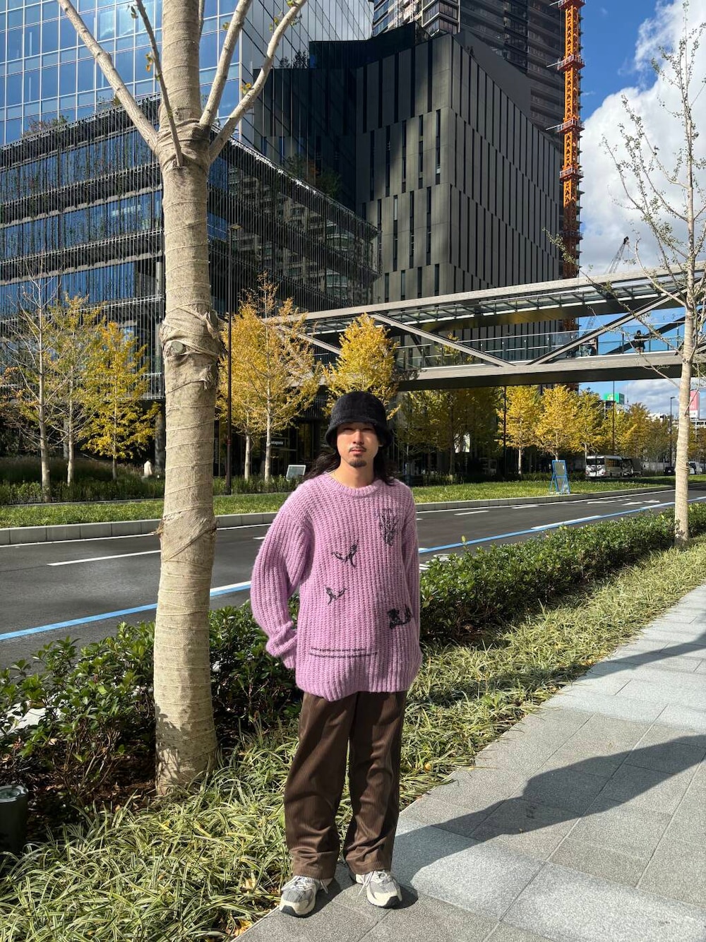 パープル系のニット/セーター、ブラウン系のその他パンツ、ブラック系のハットを着用したメンズの冬コーディネートの1枚目の写真