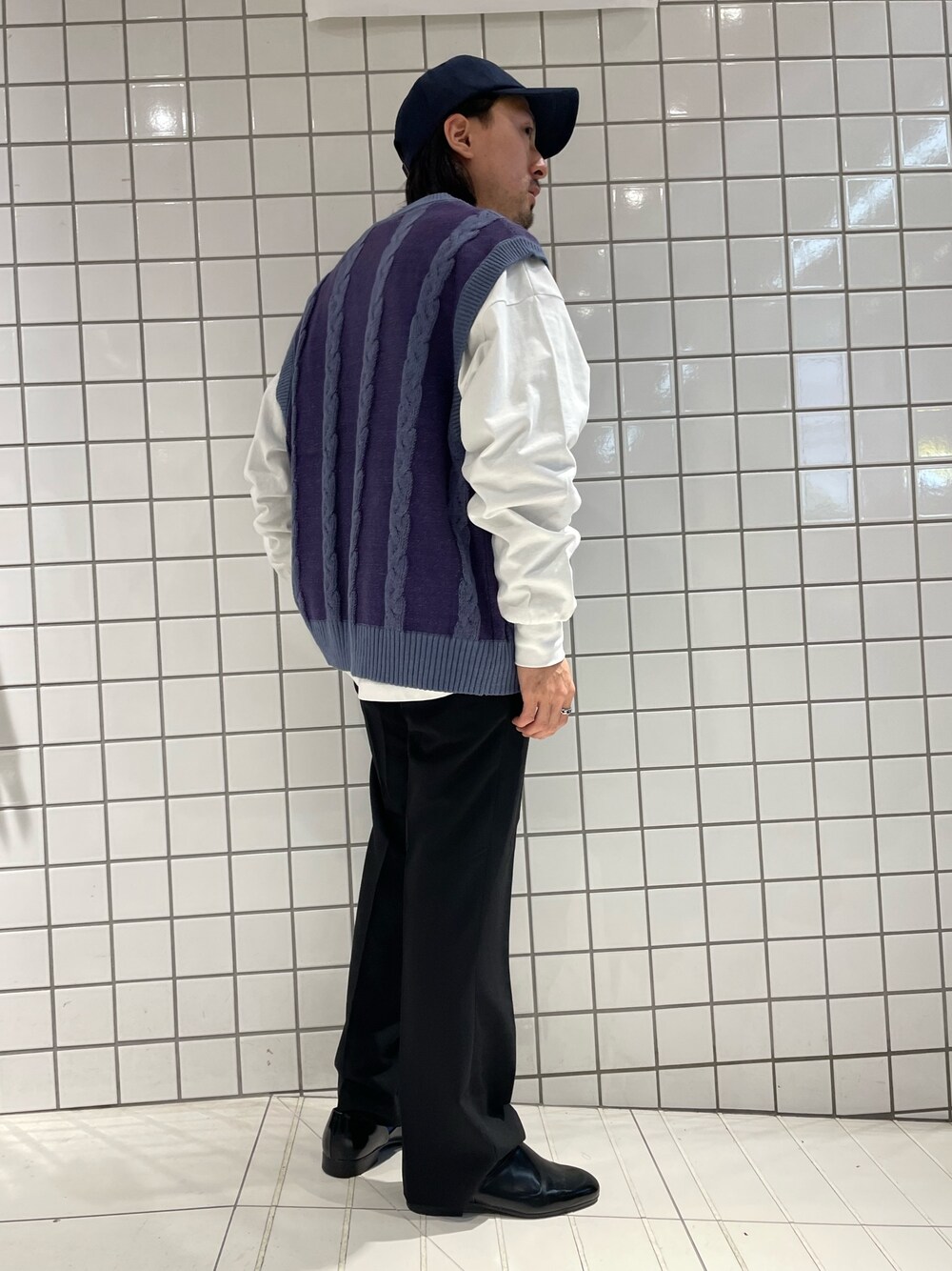 ホワイト系のTシャツ/カットソー、ブルー系のベスト、ブラック系のスラックスを着用したメンズの春コーディネートの1枚目の写真