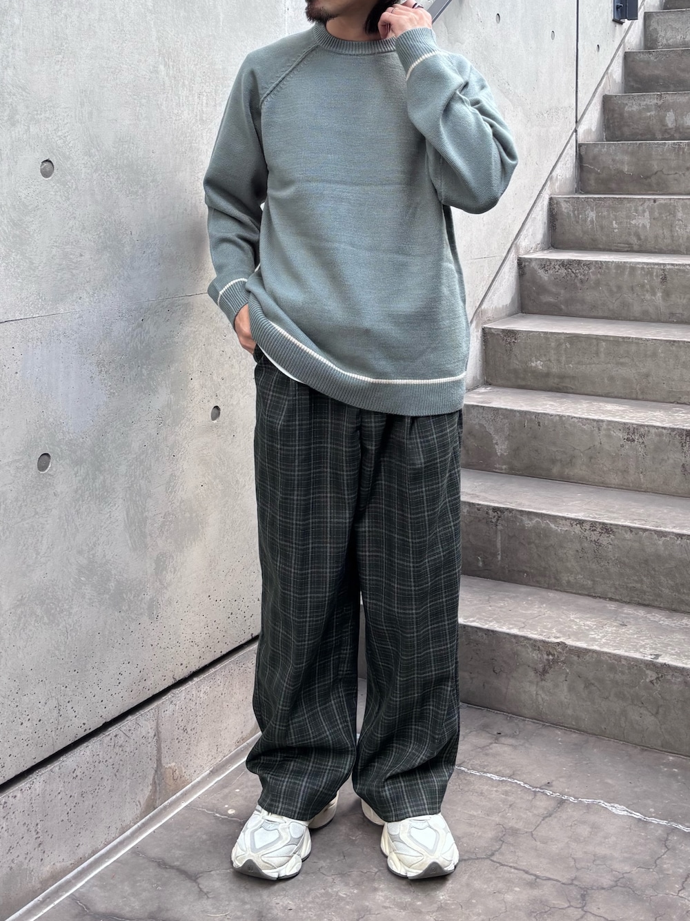 グリーン系のニット/セーター、グリーン系のスラックスを着用したメンズの秋コーディネートの1枚目の写真