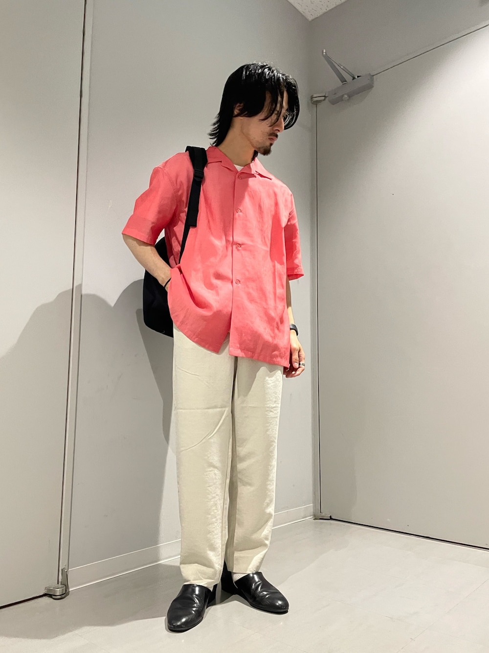 オレンジ系のシャツ/ブラウス、ホワイト系のその他パンツ、ブラック系のバックパック/リュックを着用したメンズの春コーディネートの1枚目の写真