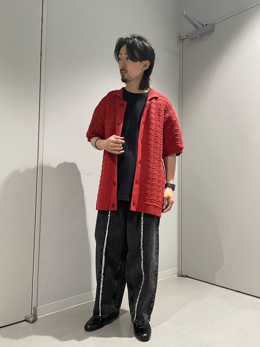 レッド系のカーディガン/ボレロ、ブラック系のデニムパンツを着用したメンズの春コーディネートの1枚目の写真