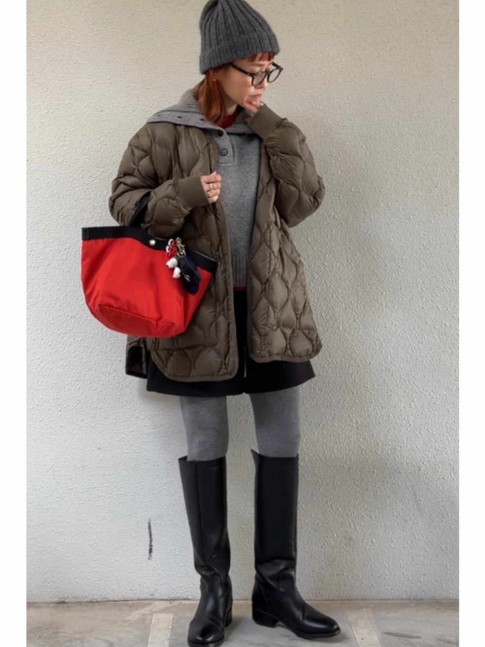 グリーン系のその他アウター、ブラック系のブーツ、グレー系のニット/セーターを着用したレディースの冬コーディネートの1枚目の写真