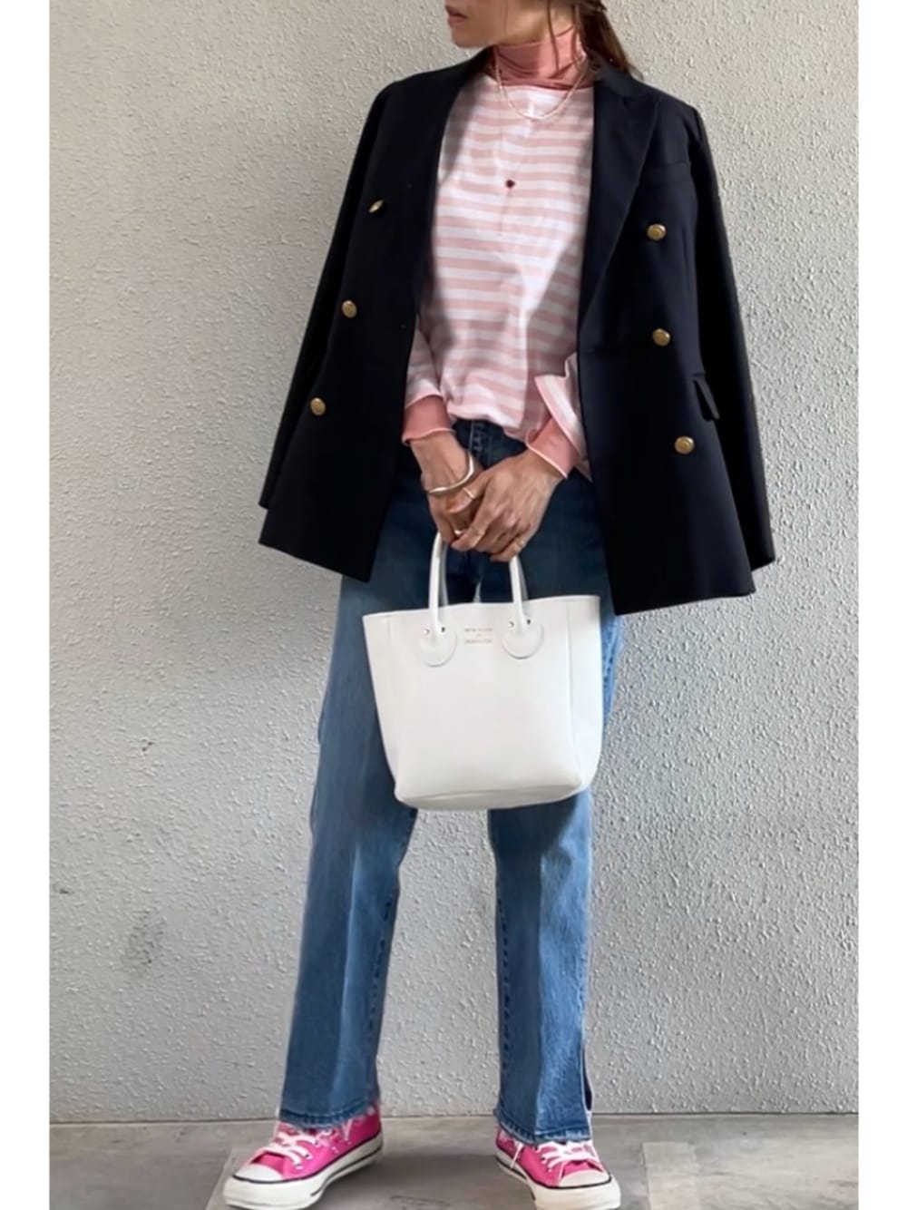 ブルー系のデニムパンツ、ホワイト系のトートバッグ、ピンク系のスニーカーを着用したレディースの春コーディネートの1枚目の写真