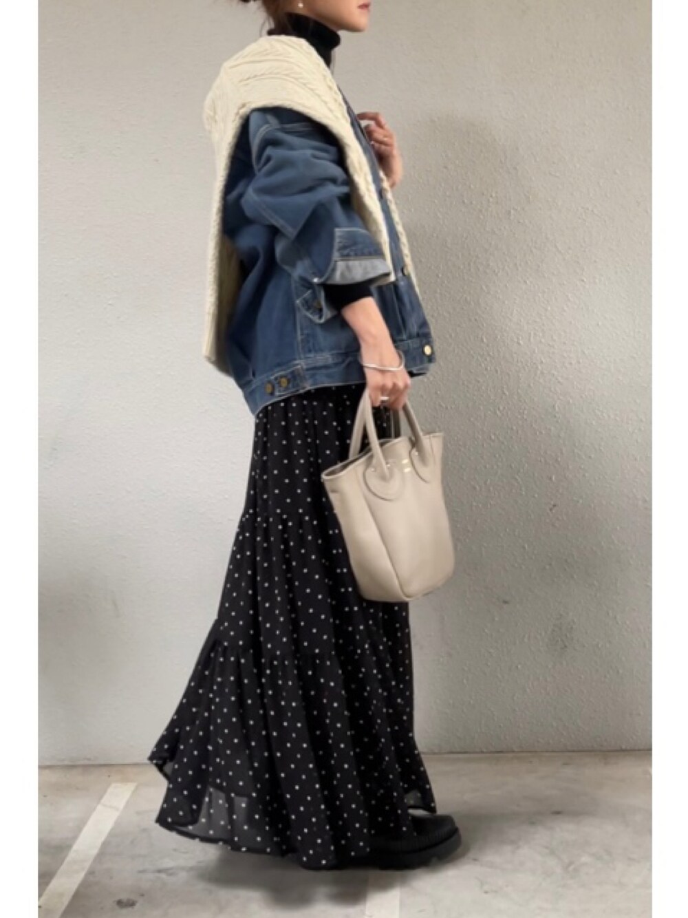 ブルー系のブルゾン、ホワイト系のニット/セーター、ベージュ系のトートバッグを着用したレディースの冬コーディネートの1枚目の写真