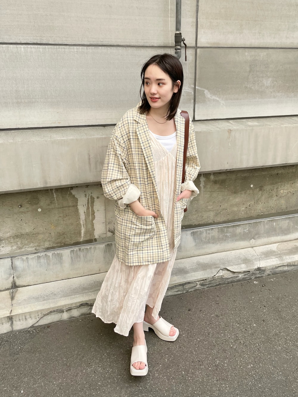 ホワイト系のサンダル、ホワイト系のワンピース、ブルー系のテーラードジャケットを着用したレディースの春コーディネートの1枚目の写真