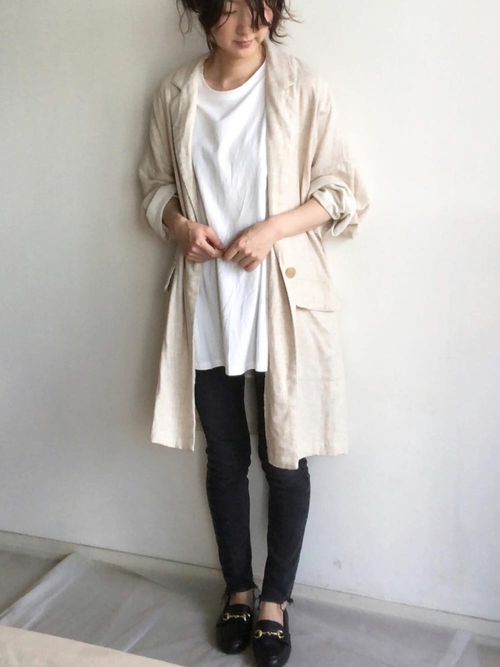 ブラック系のデニムパンツ、ブラック系のローファー、ベージュ系のジャケット/アウターを着用したレディースの秋コーディネートの1枚目の写真