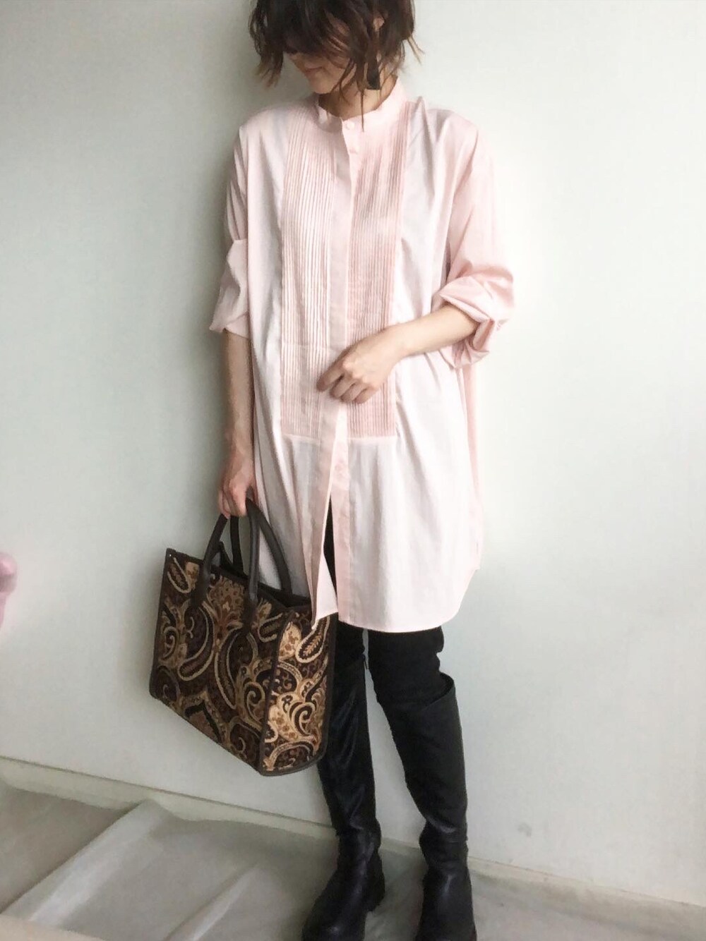 ピンク系のシャツ/ブラウス、ブラック系のブーツ、ブラック系のトートバッグを着用したレディースの秋コーディネートの1枚目の写真