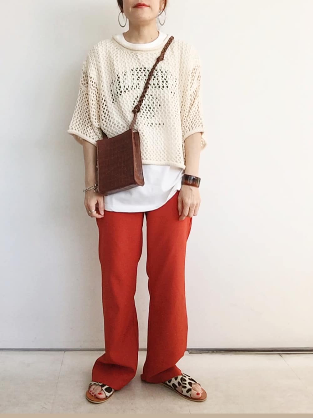 「ANGIE VINTAGE、Angie、angie_vintage、カラーパンツ、オレンジ、メッシュ、透かし編みニット、レイヤードスタイル、カジュアルコーデ、サンダル、ショルダーバッグ、オトナカジュアル」｜「ANGIEの【haru_wearコラボ】透かし編みメッシュクロップドニット（ニット/セーター、ホワイト系）」を使った、SACHIさん（レディース・150cm）の春コーディネートの1枚目の写真