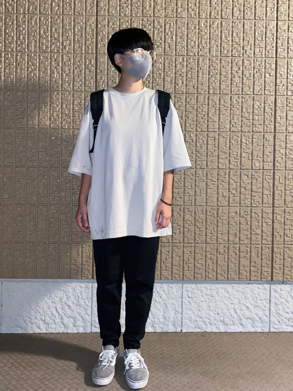 グレー系のTシャツ/カットソー、ブラック系のバックパック/リュック、グレー系のスニーカーを着用したレディースの秋コーディネートの1枚目の写真