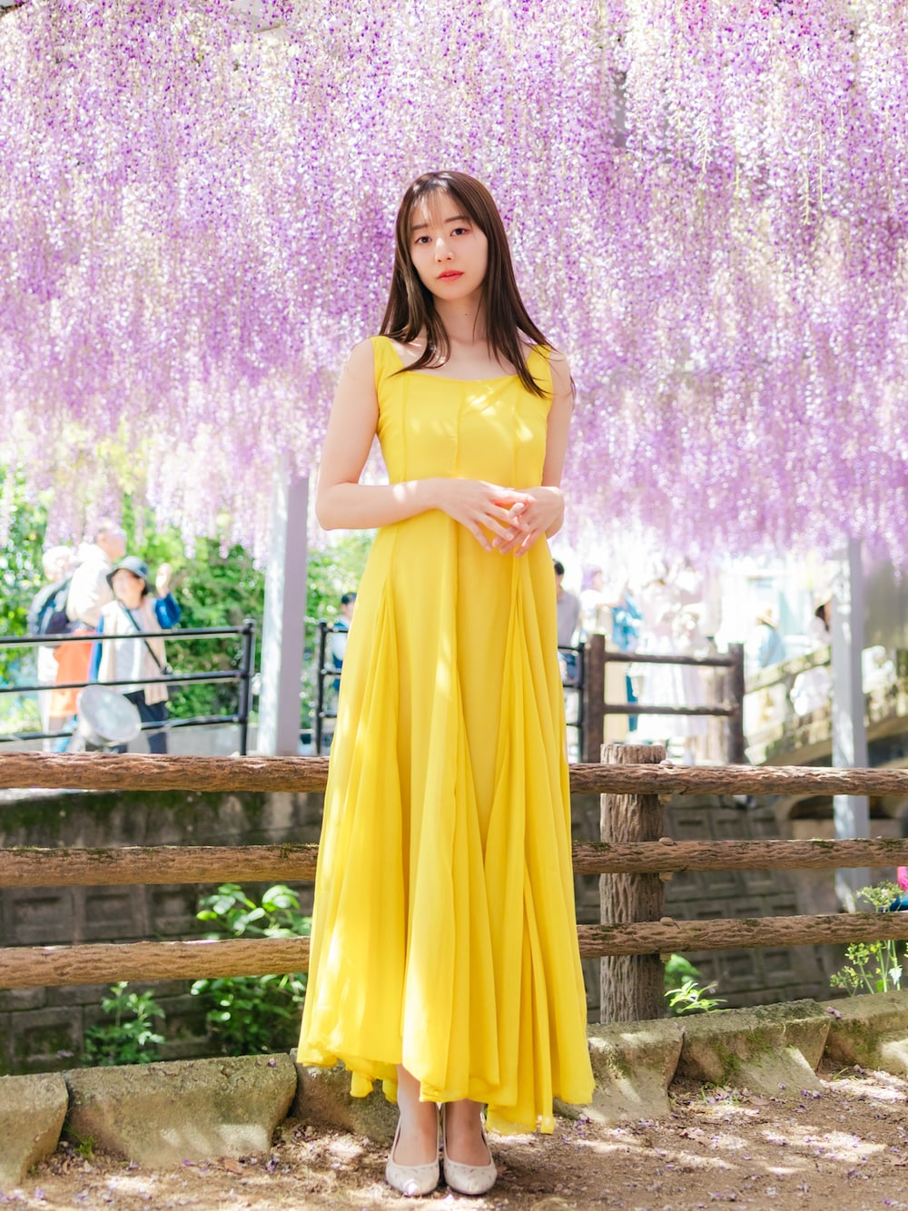 イエロー系のワンピース/ドレス、ホワイト系のパンプスを着用したレディースの春コーディネートの1枚目の写真