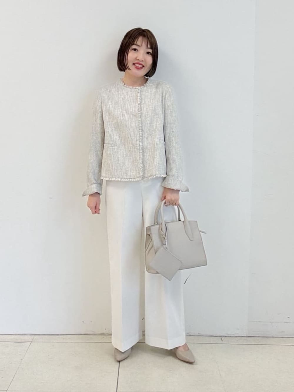 ベージュ系のパンプス、ホワイト系のその他パンツ、ホワイト系のノーカラージャケットを着用したレディースの春コーディネートの1枚目の写真