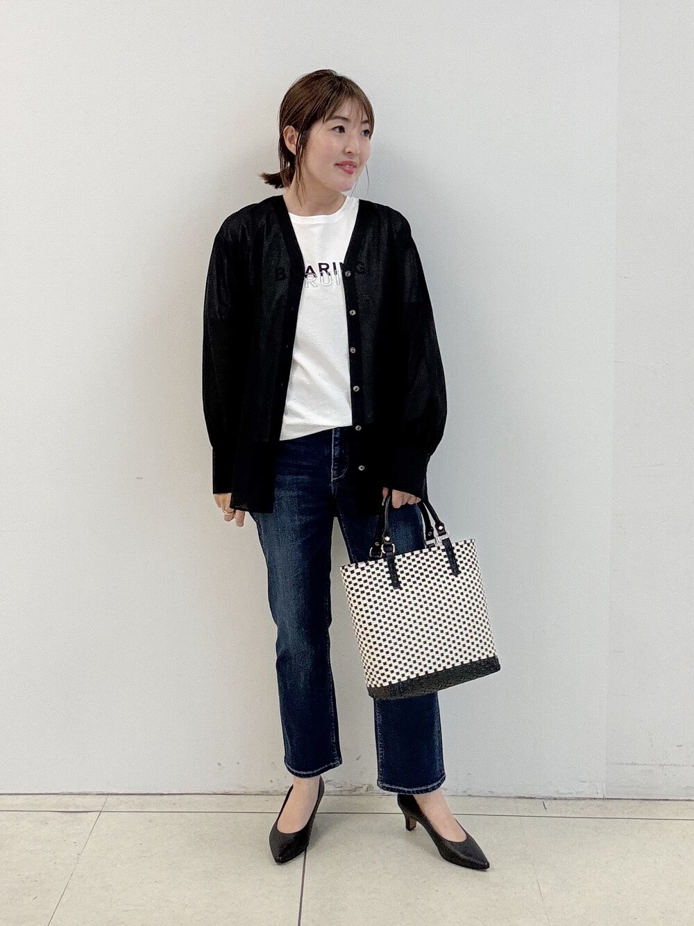 ブラック系のパンプス、ブラック系のシャツ/ブラウス、ホワイト系のTシャツ/カットソーを着用したレディースの春コーディネートの1枚目の写真
