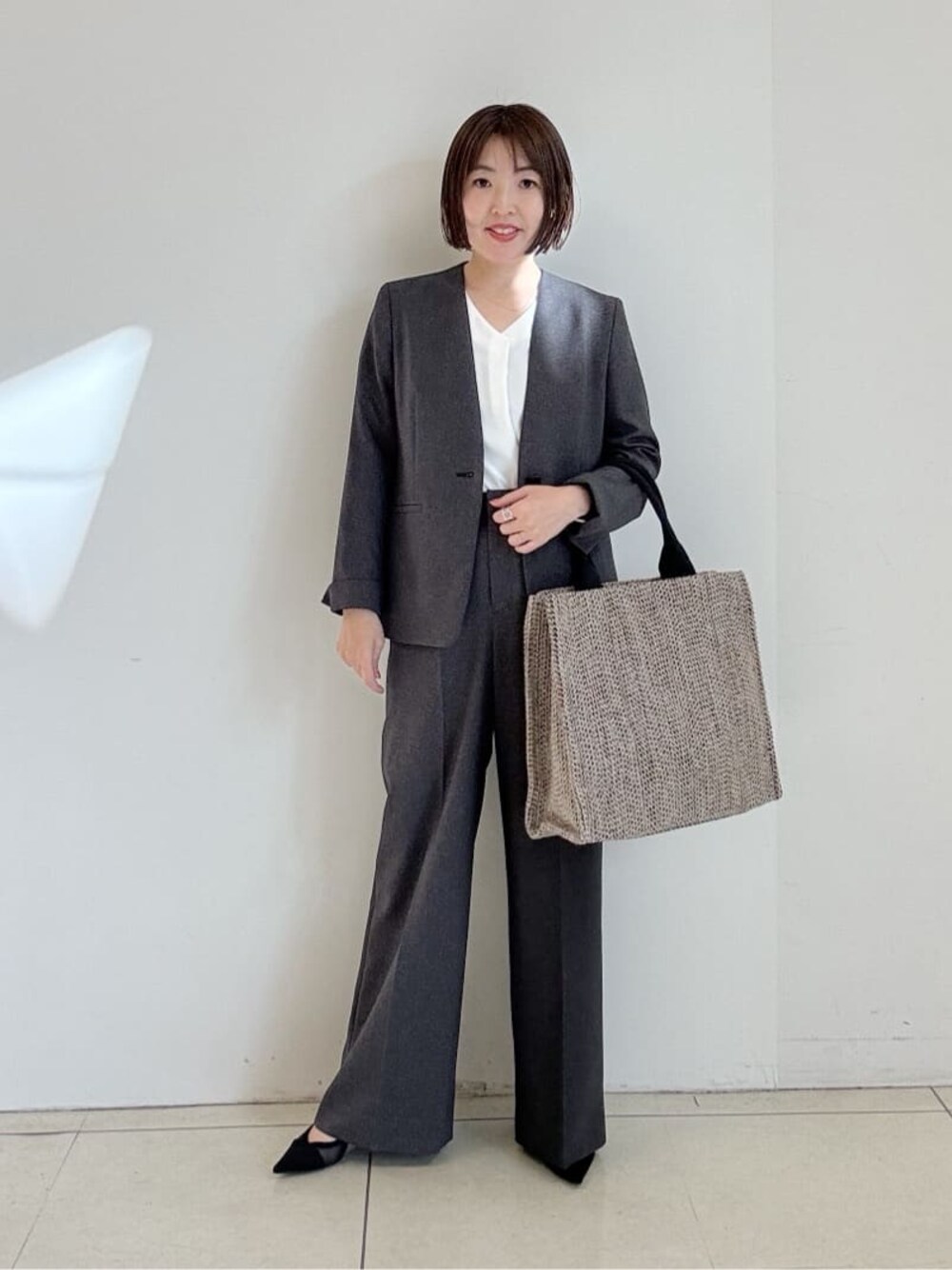 グレー系のスーツパンツ、グレー系のスーツジャケット、ホワイト系のシャツ/ブラウスを着用したレディースの冬コーディネートの1枚目の写真