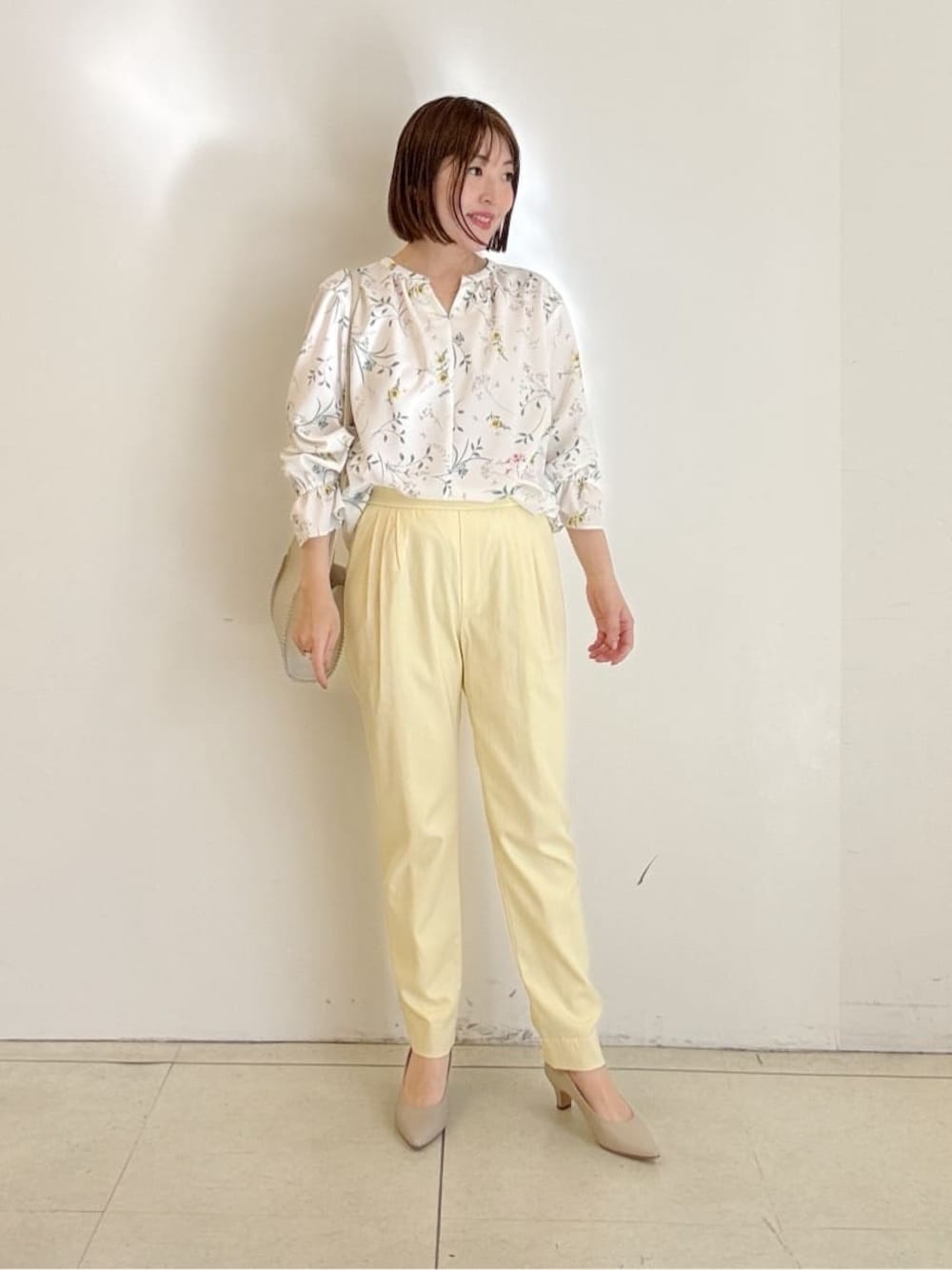 ベージュ系のパンプス、イエロー系のその他パンツ、ホワイト系のシャツ/ブラウスを着用したレディースの春コーディネートの1枚目の写真