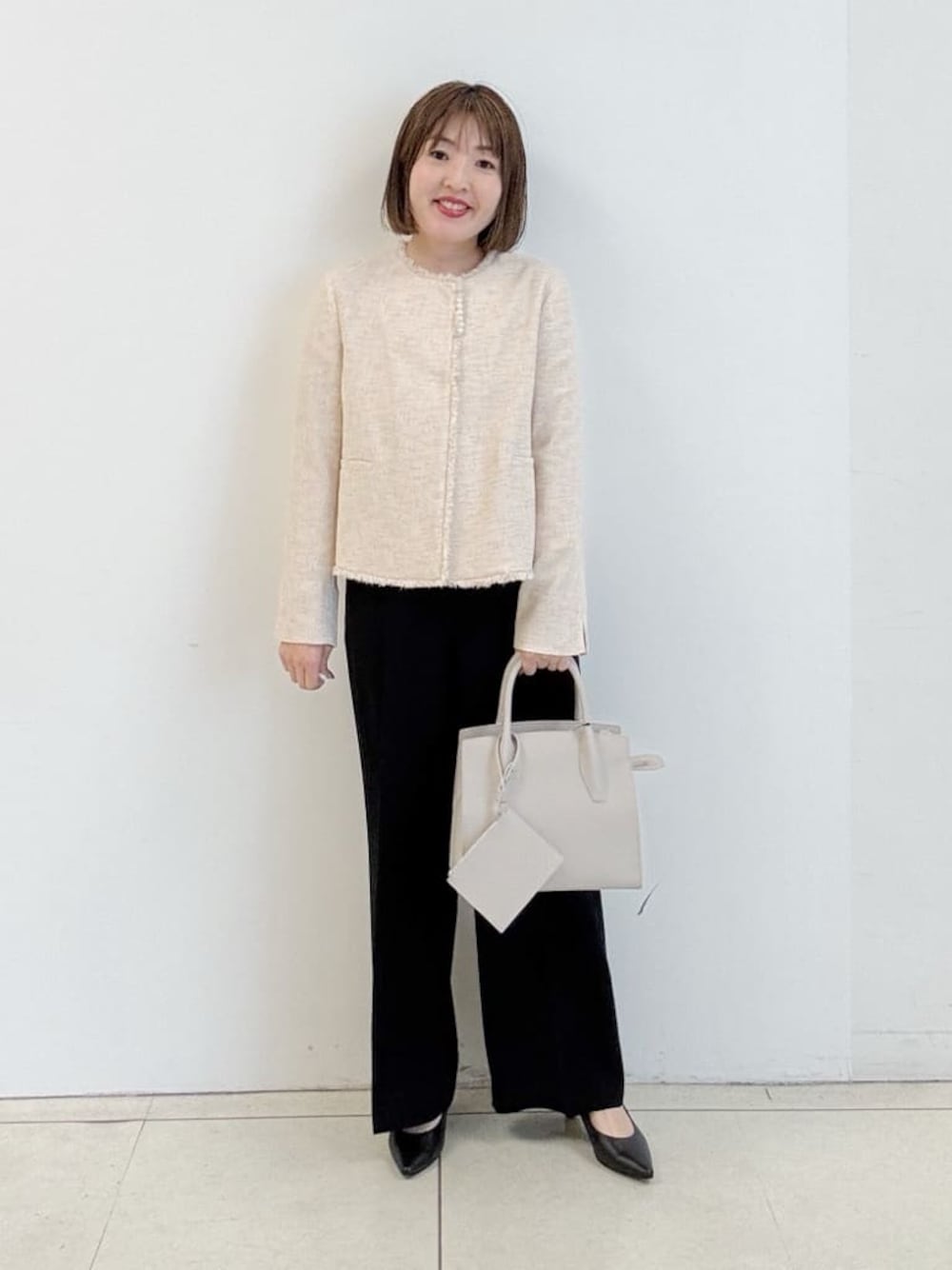 ブラック系のその他パンツ、ブラック系のパンプス、ベージュ系のノーカラージャケットを着用したレディースの春コーディネートの1枚目の写真