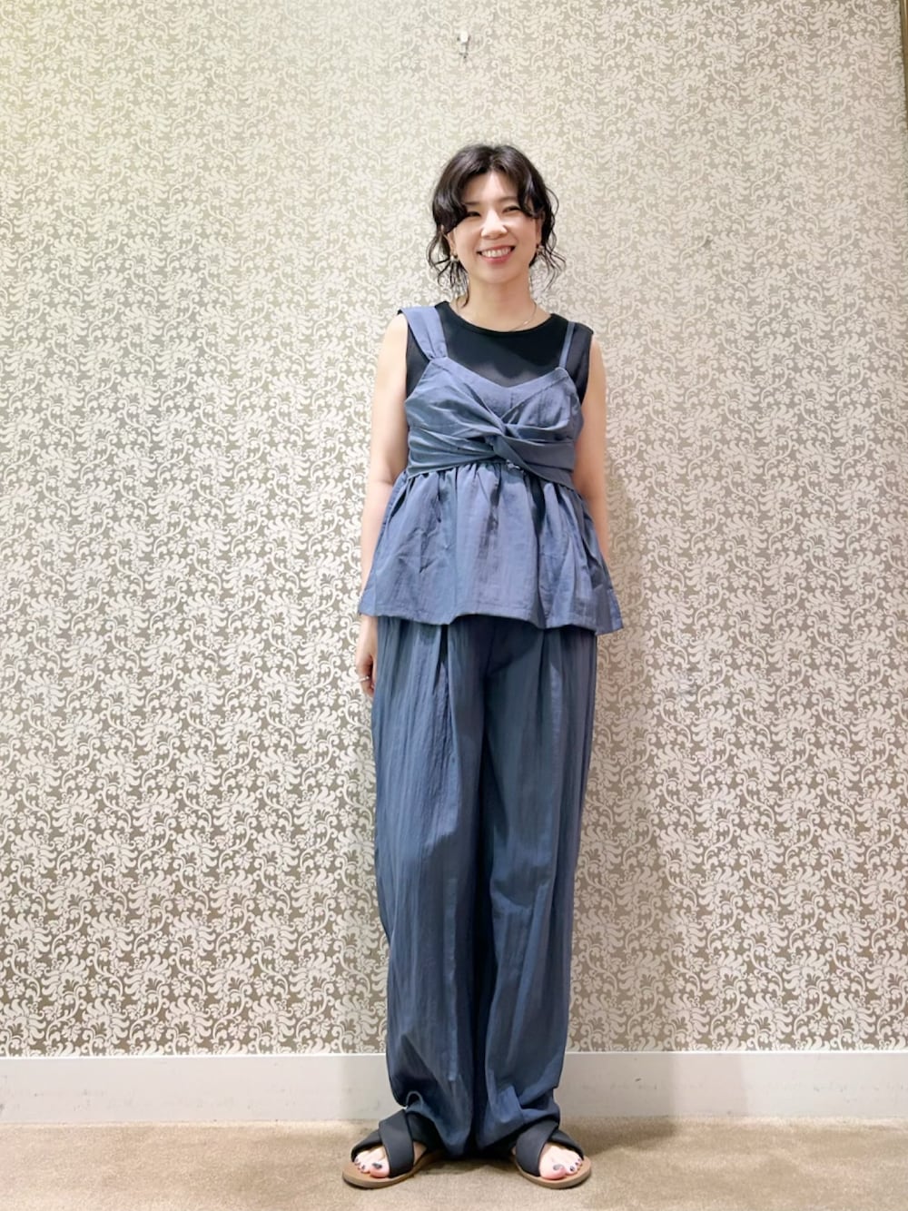 ブルー系のベスト、ブルー系のその他パンツ、ブラック系のタンクトップを着用したレディースの夏コーディネートの1枚目の写真