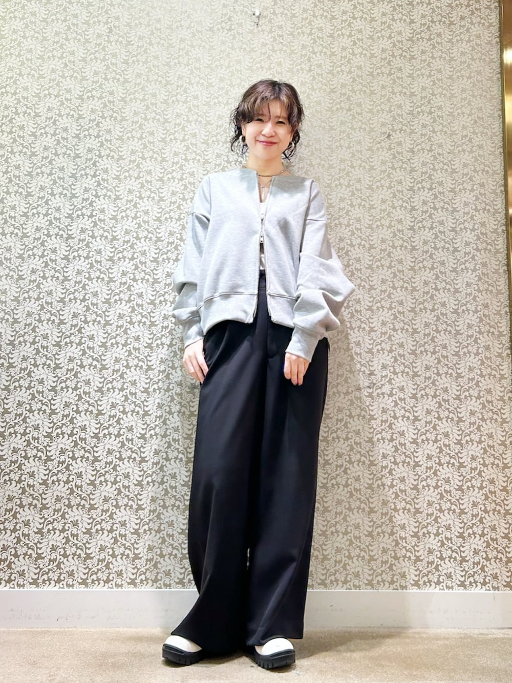 グレー系のスウェット、ブラック系のその他パンツ、ホワイト系のブーツを着用したレディースの冬コーディネートの1枚目の写真