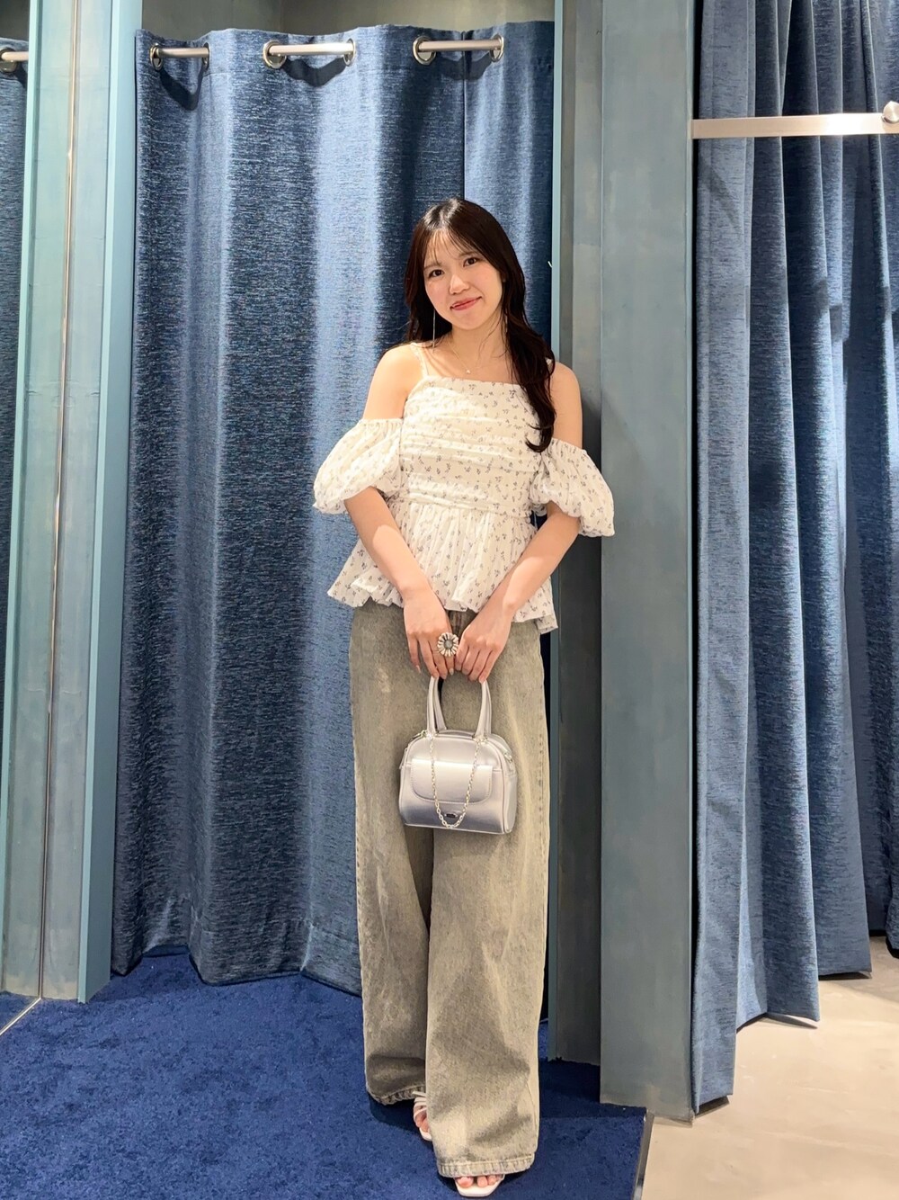 ホワイト系のシャツ/ブラウス、ブルー系のデニムパンツ、シルバー系のボストンバッグを着用したレディースの春コーディネートの1枚目の写真