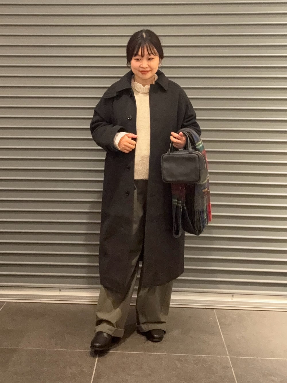 ベージュ系のニット/セーター、グレー系のその他アウター、ブラック系のボストンバッグを着用したレディースの秋コーディネートの1枚目の写真