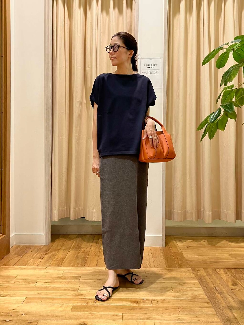 ブルー系のTシャツ/カットソー、グレー系のスカート、オレンジ系のトートバッグを着用したレディースの夏コーディネートの1枚目の写真