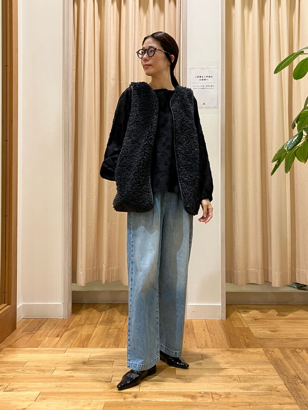 ブラック系のシャツ/ブラウス、グレー系のその他アウター、ブルー系のデニムパンツを着用したレディースの秋コーディネートの1枚目の写真