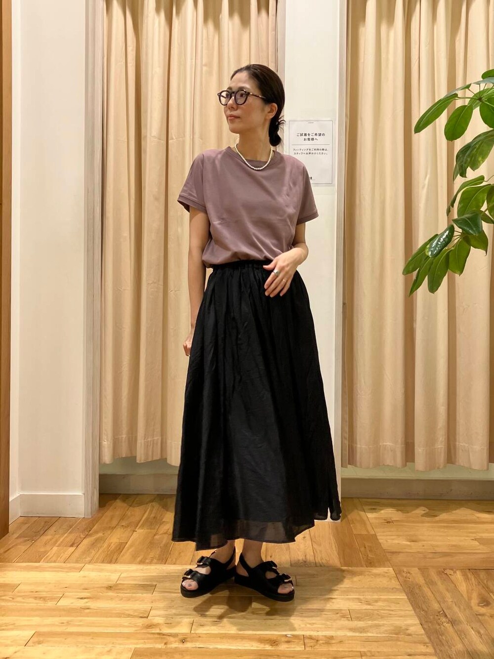 ブラック系のスカート、レッド系のTシャツ/カットソー、ブラック系のサンダルを着用したレディースの夏コーディネートの1枚目の写真