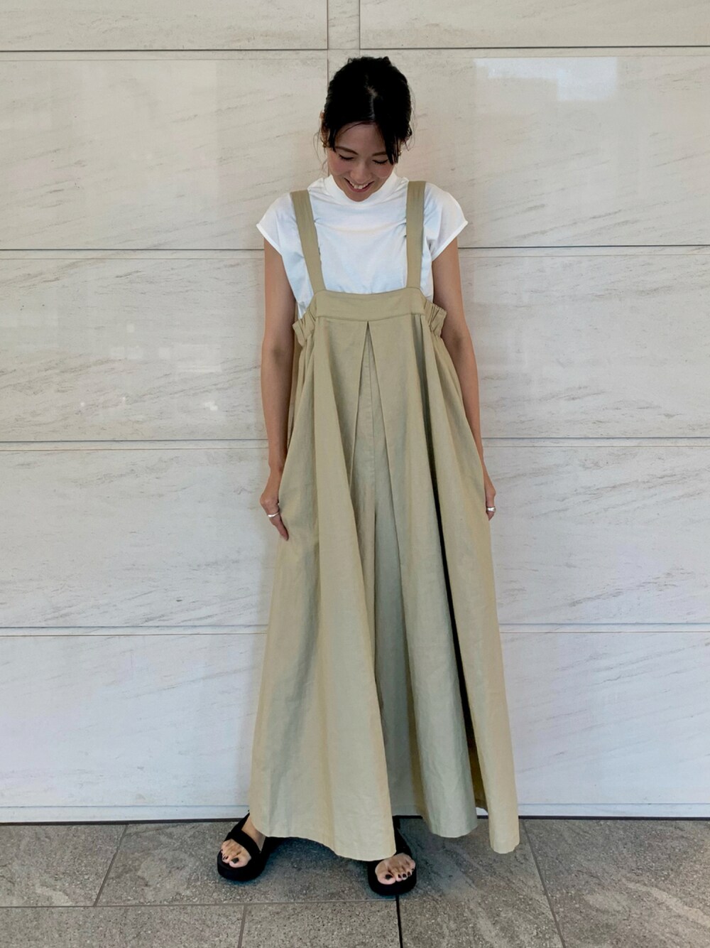 ホワイト系のTシャツ/カットソー、ベージュ系のサロペット/オーバーオール、ブラック系のサンダルを着用したレディースの夏コーディネートの1枚目の写真