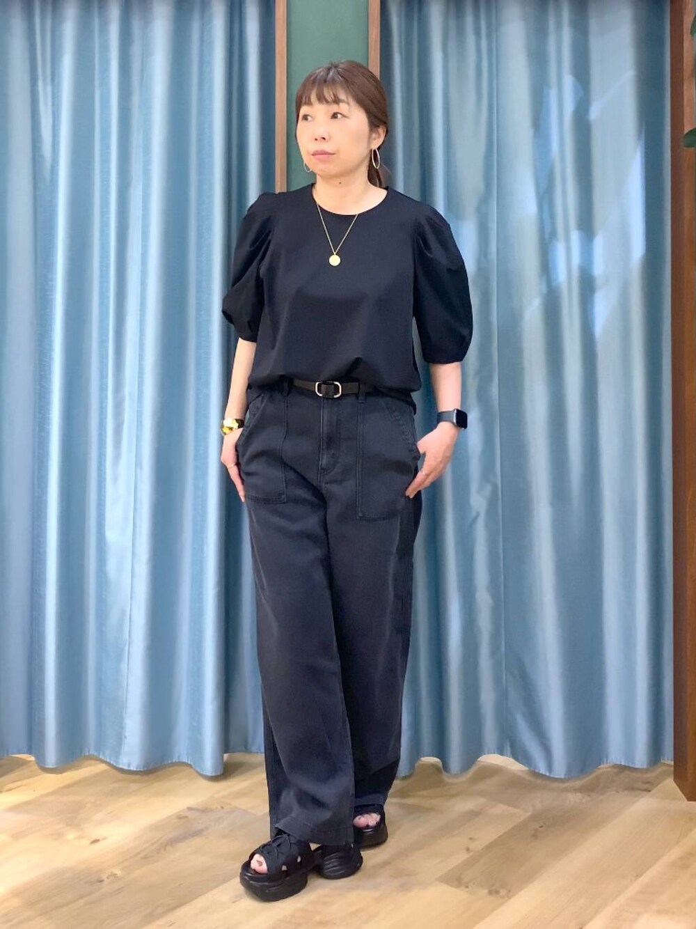 グレー系のデニムパンツ、ブラック系のシャツ/ブラウス、ブラック系のサンダルを着用したレディースの春コーディネートの1枚目の写真