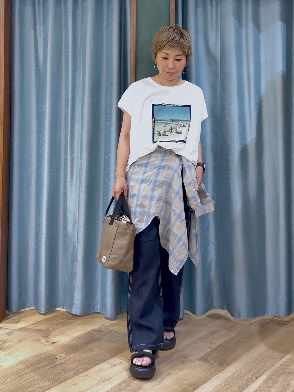ホワイト系のTシャツ/カットソー、ブルー系のその他パンツ、ベージュ系のショルダーバッグを着用したレディースの夏コーディネートの1枚目の写真