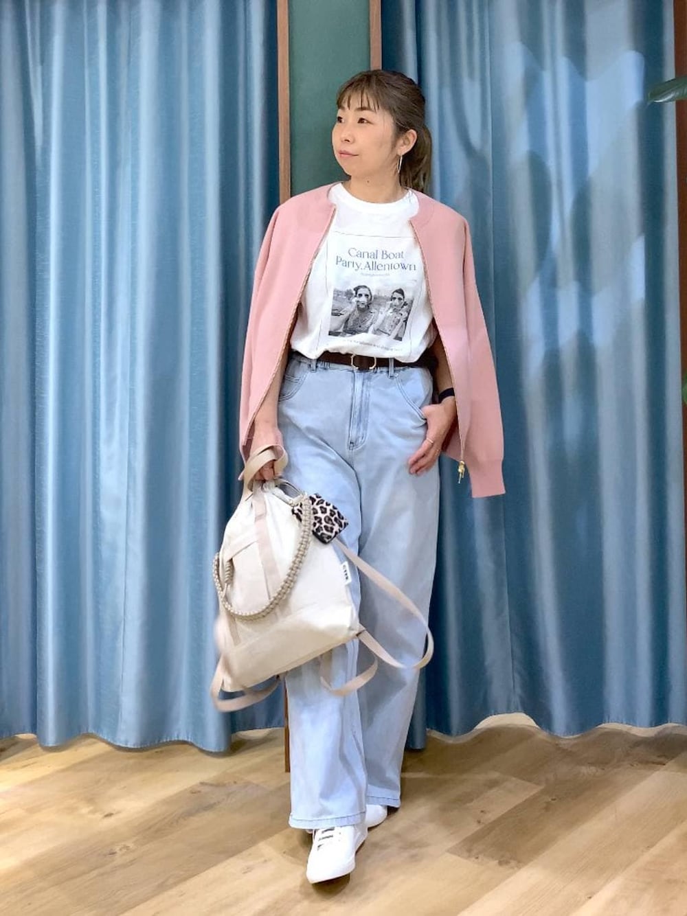 グレー系のカーディガン/ボレロ、ベージュ系のバックパック/リュック、ブラウン系のスニーカーを着用したレディースの冬コーディネートの1枚目の写真