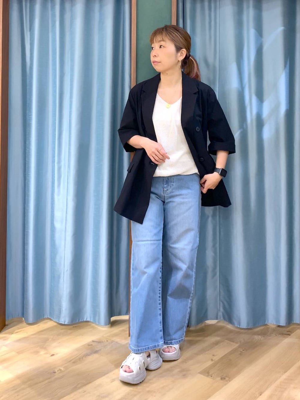 ブルー系のデニムパンツ、ホワイト系のタンクトップ、ブラック系のテーラードジャケットを着用したレディースの春コーディネートの1枚目の写真