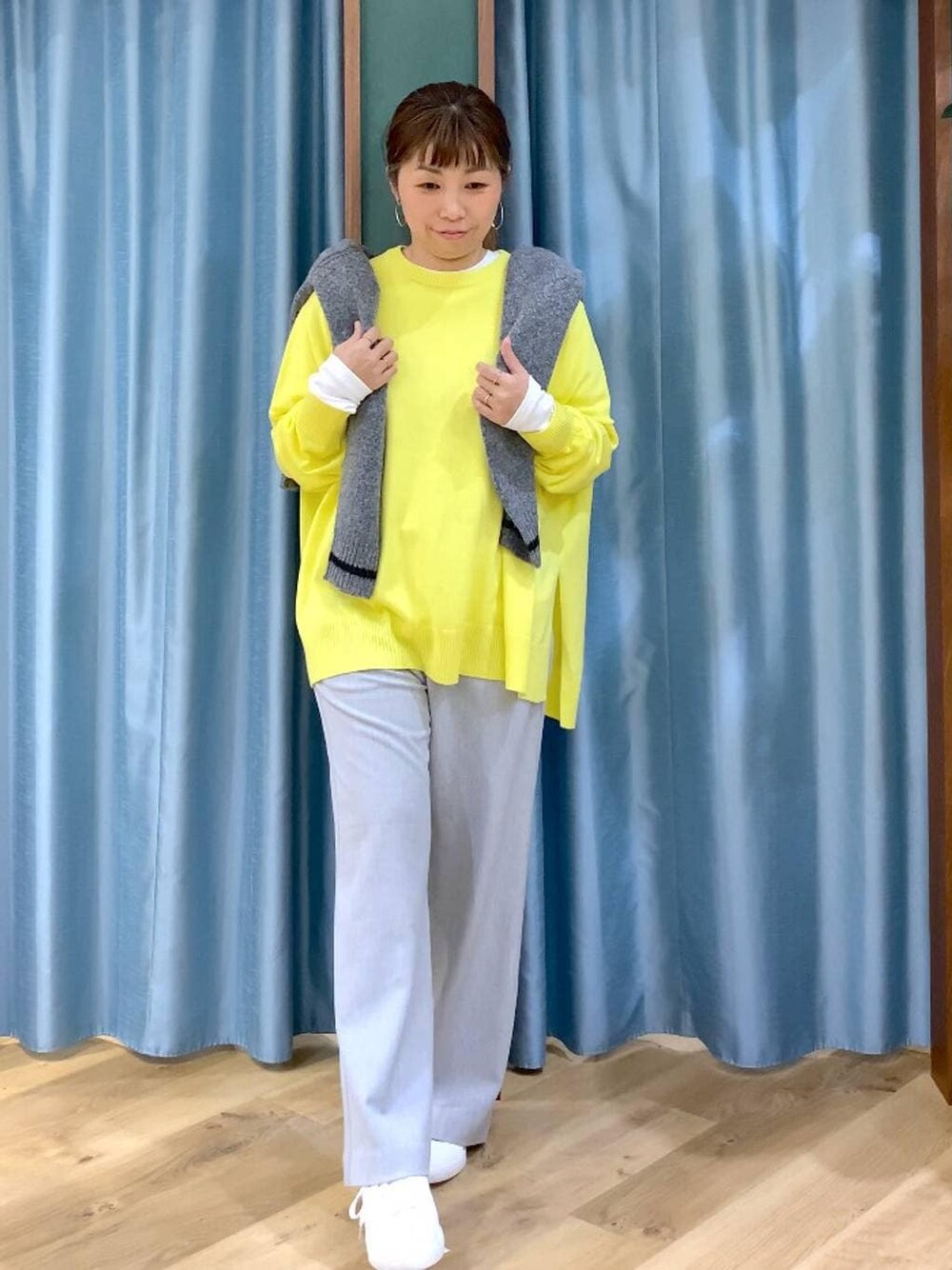 グレー系のカーディガン/ボレロ、ホワイト系のTシャツ/カットソー、イエロー系のニット/セーターを着用したレディースの秋コーディネートの1枚目の写真