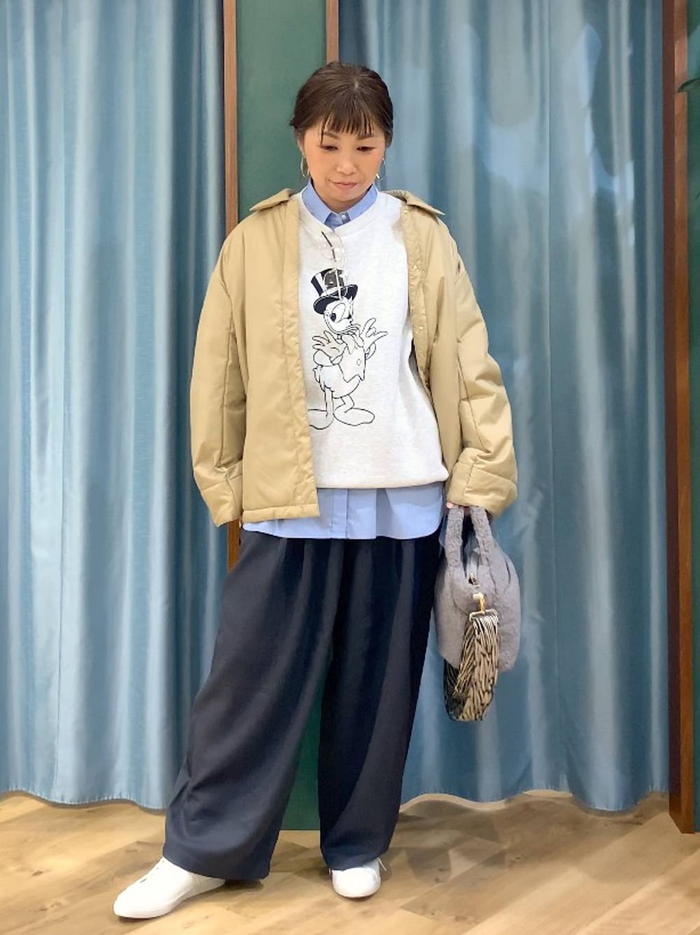 ベージュ系のブルゾン、ブルー系のシャツ/ブラウス、グレー系のスラックスを着用したレディースの秋コーディネートの1枚目の写真