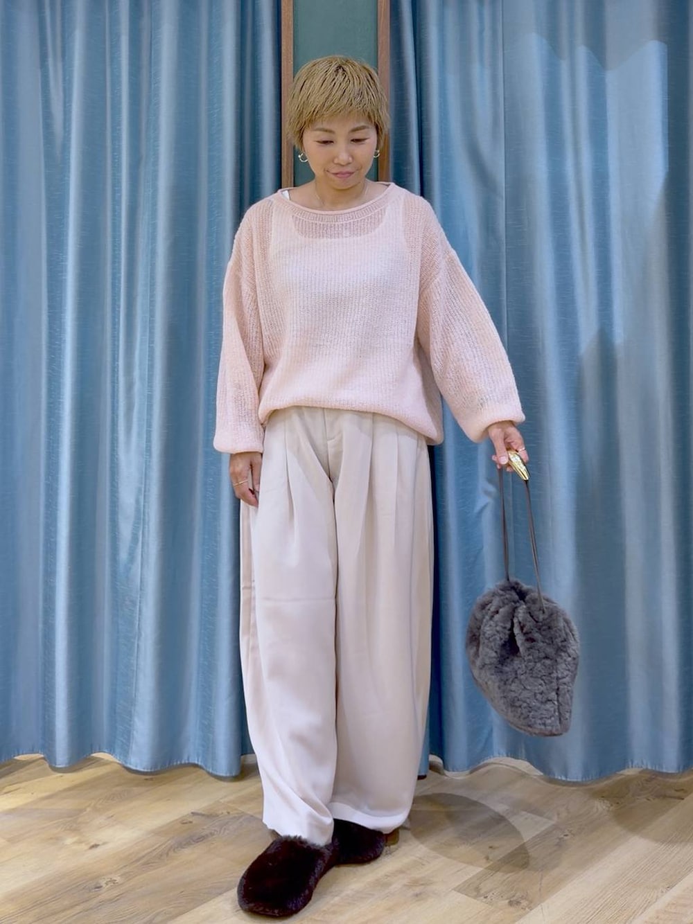 グレー系のハンドバッグ、ブラウン系のその他シューズ、ピンク系のスラックスを着用したレディースの秋コーディネートの1枚目の写真