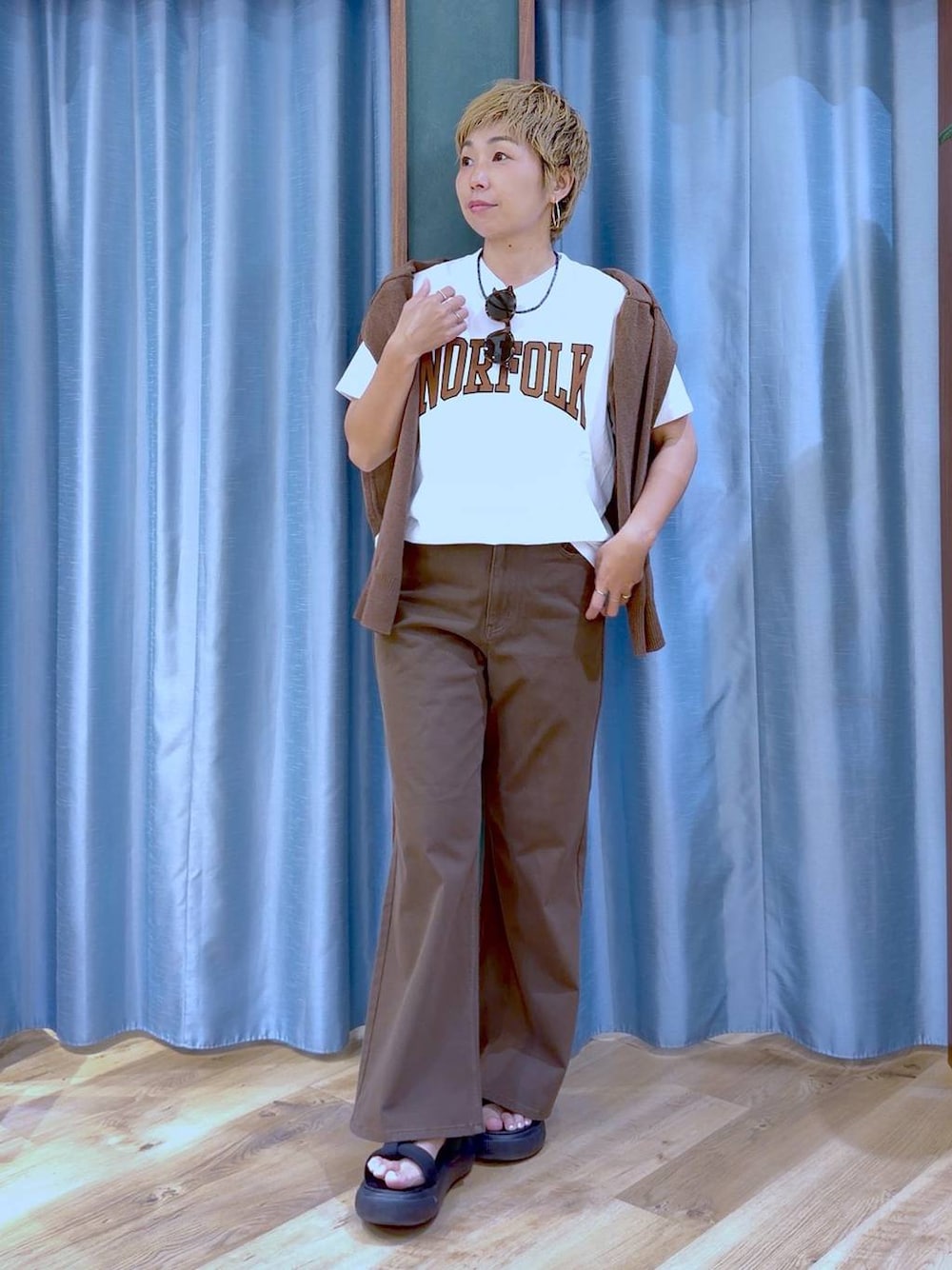 ブラック系のサンダル、ブラウン系のカーディガン/ボレロ、ホワイト系のTシャツ/カットソーを着用したレディースの夏コーディネートの1枚目の写真