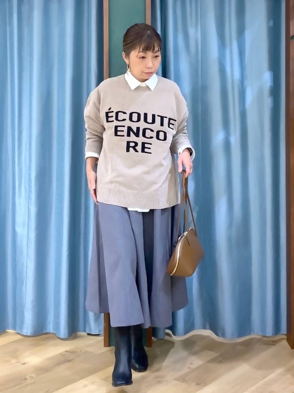 イエロー系のトートバッグ、ホワイト系のシャツ/ブラウス、ベージュ系のニット/セーターを着用したレディースの秋コーディネートの1枚目の写真