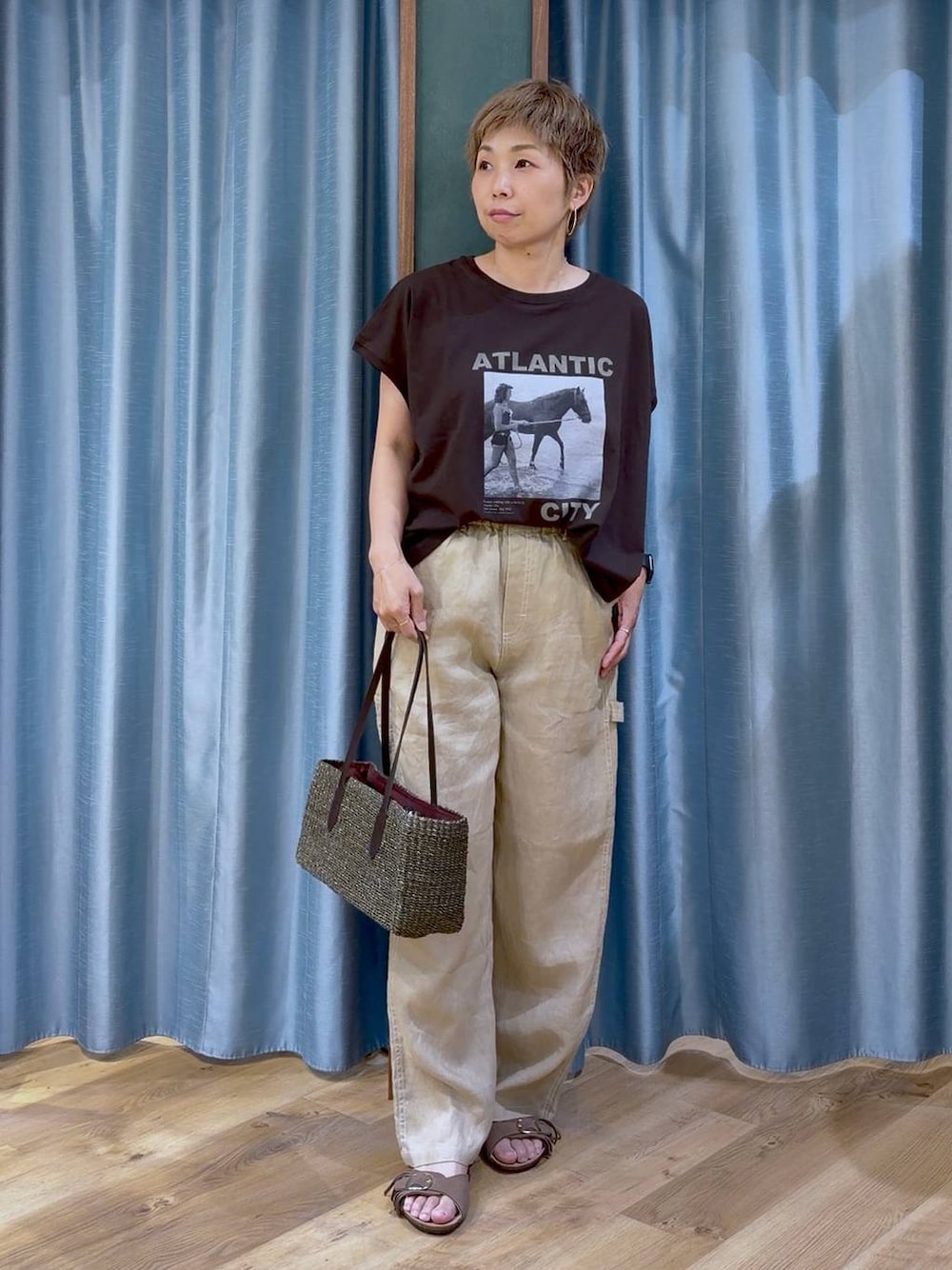 ブラウン系のTシャツ/カットソー、ベージュ系のその他パンツ、ブラウン系のサンダルを着用したレディースの夏コーディネートの1枚目の写真