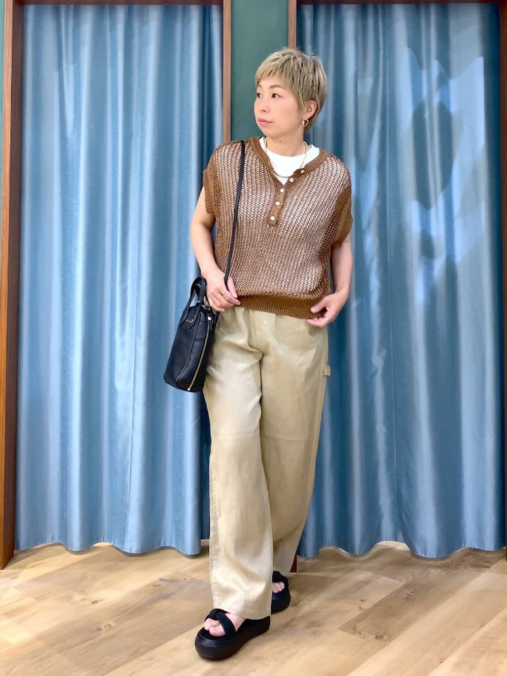 ホワイト系のTシャツ/カットソー、ベージュ系のその他パンツ、ブラック系のショルダーバッグを着用したレディースの夏コーディネートの1枚目の写真