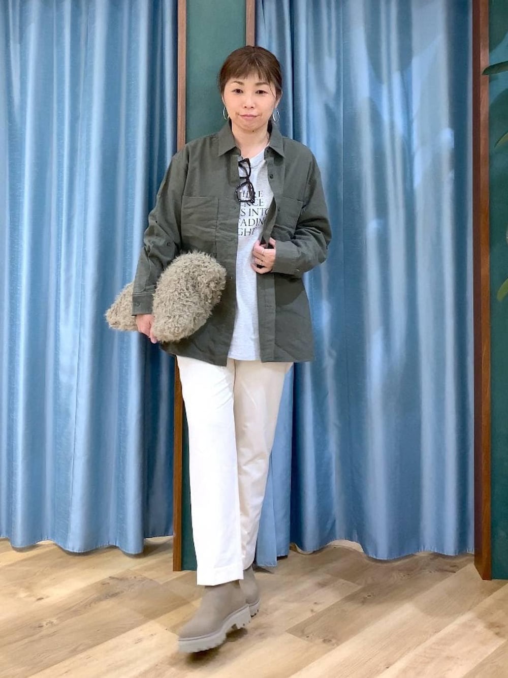 ベージュ系のハンドバッグ、ベージュ系のブーツ、ホワイト系のTシャツ/カットソーを着用したレディースの冬コーディネートの1枚目の写真