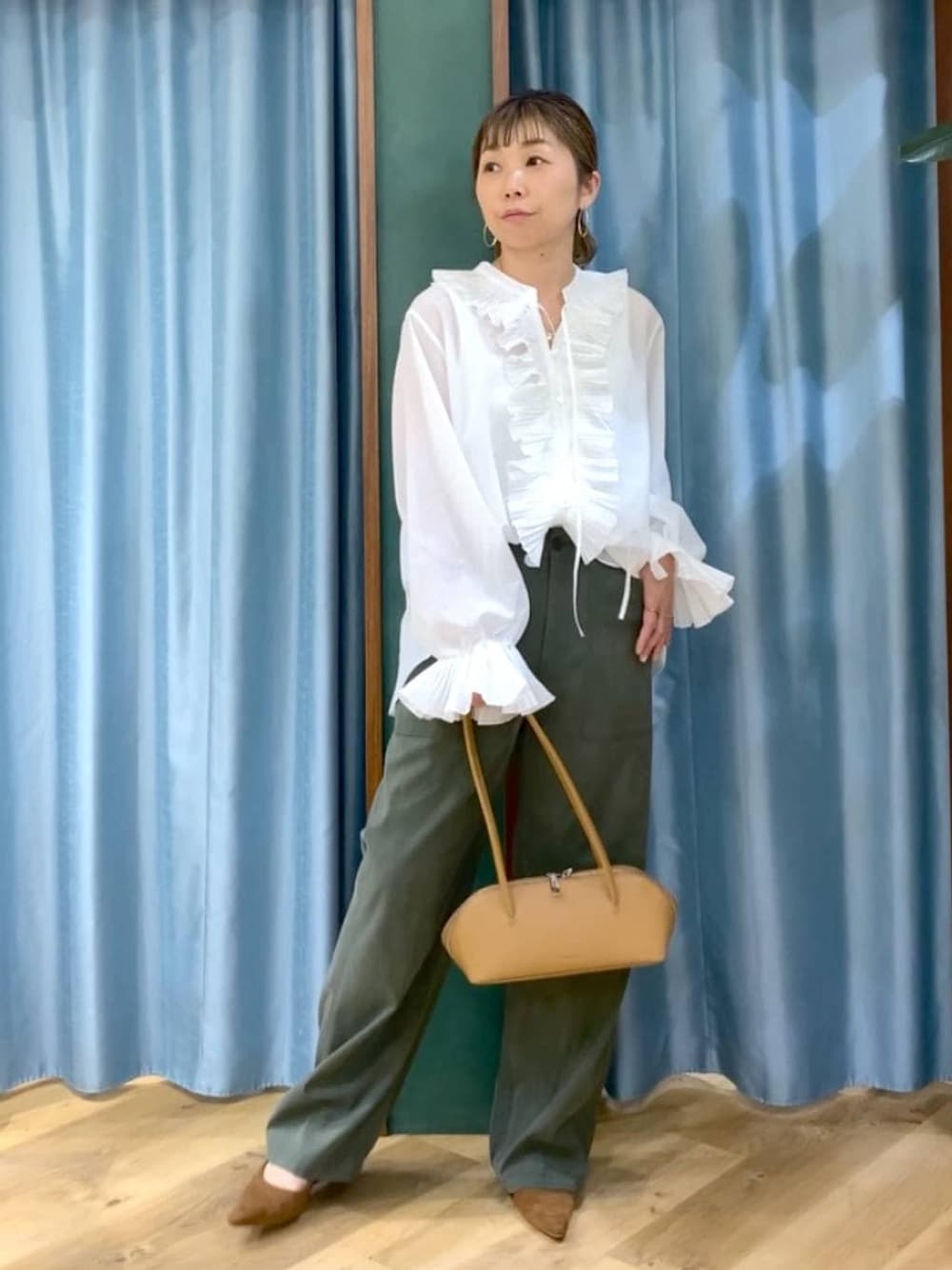 グリーン系のその他パンツ、ホワイト系のシャツ/ブラウス、イエロー系のパンプスを着用したレディースの冬コーディネートの1枚目の写真