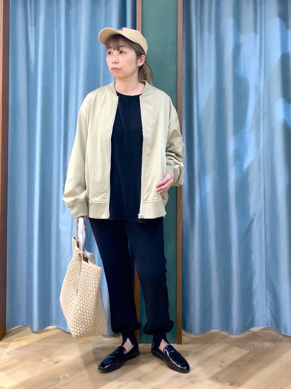 ベージュ系のMA-1、ブラック系のTシャツ/カットソー、ベージュ系のトートバッグを着用したレディースの冬コーディネートの1枚目の写真