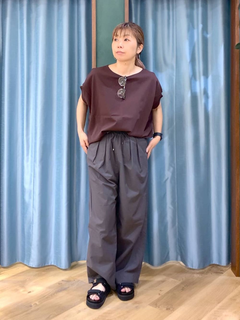 グレー系のその他パンツ、ブラウン系のTシャツ/カットソー、ブラック系のサンダルを着用したレディースの春コーディネートの1枚目の写真